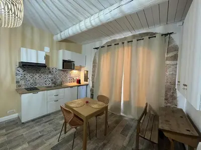 a kitchen with a table and chairs in a room at Studio centre de Charleval in Charleval