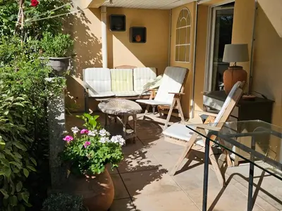 a patio with chairs and a table and flowers at Aix centre, 2 room apartment garden, parking in Aix-en-Provence