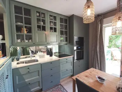 a kitchen with green cabinets and a wooden table at Aix centre, 2 room apartment garden, parking in Aix-en-Provence
