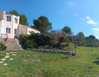 a house on a hill with a garden in front of it at Maison provençale de charme in Velaux