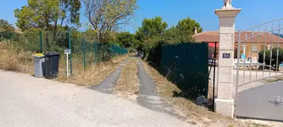 a fence on the side of a road next to a street at Maison provençale de charme in Velaux