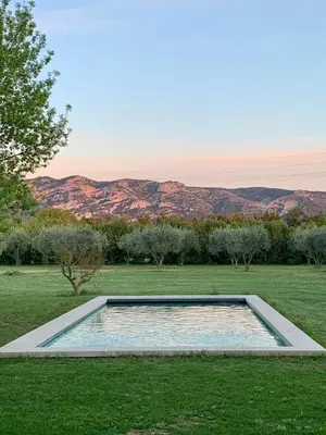 a swimming pool in a field with mountains in the background at House with heated swimming pool and breathtaking views of the Luberon in Robion en Luberon