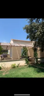 a house with a bench and a tree in front of it at Location maison provençale in Plan-dʼOrgon