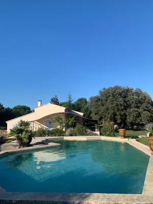 a swimming pool in front of a house at Location maison provençale in Plan-dʼOrgon