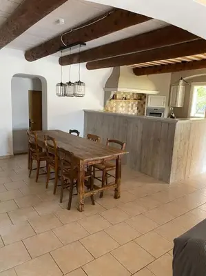 a dining room with a wooden table and chairs at Location maison provençale in Plan-dʼOrgon