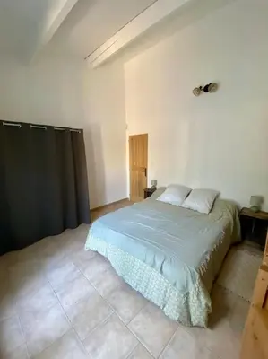 a bedroom with a bed in a white room at Location maison provençale in Plan-dʼOrgon