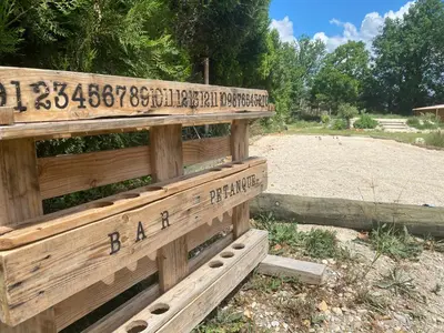 a wooden bench in a park with writing on it at Le Mas des iscles Mallemort in Mallemort