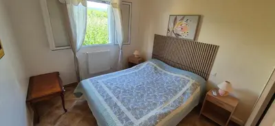 a bedroom with a bed with a blue blanket on it at Résidence Les Salettes in Mormoiron
