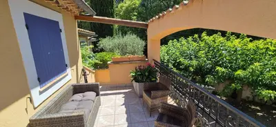 a balcony with chairs and a blue door and plants at Résidence Les Salettes in Mormoiron