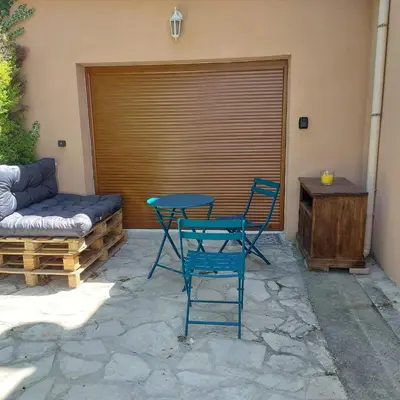 a patio with a table and chairs and a couch at Studio 25m2 in LʼIsle-sur-la-Sorgue