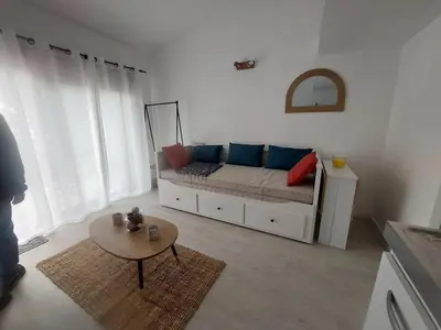a living room with a couch and a table at Studio 25m2 in LʼIsle-sur-la-Sorgue