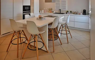 a kitchen with a white table and bar stools at villa in Châteauneuf-de-Gadagne