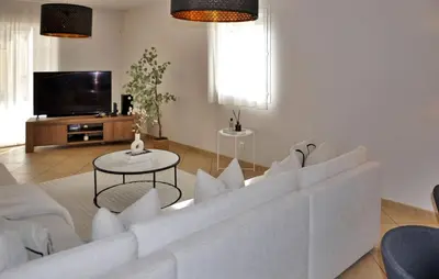 a living room with a white couch and a tv at villa in Châteauneuf-de-Gadagne