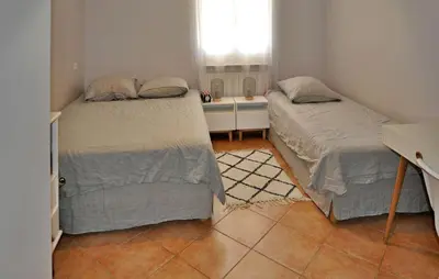 two beds in a small room with a window at villa in Châteauneuf-de-Gadagne