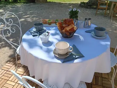a white table with a basket of croissants on it at LE Mas Pacha in LʼIsle-sur-la-Sorgue