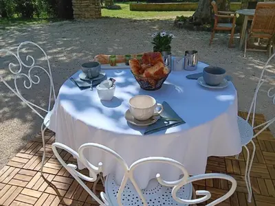 a white table with a bowl of bread on it at LE Mas Pacha in LʼIsle-sur-la-Sorgue