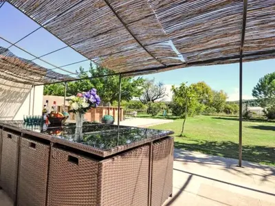 an outdoor kitchen with a glass counter with flowers on it at Gîte en Provence entre Pernes les fontaines et St Didier proche l'isle sur sorgues face Mont Ventoux Villa avec piscine in Saint-Didier