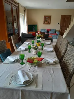 a dining table with a white table cloth and plates and glasses at La Bartavelle in Eyragues
