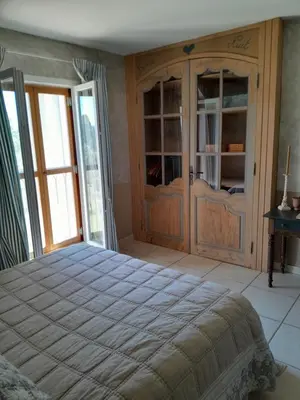 a bedroom with a large bed and a glass door at La Bartavelle in Eyragues