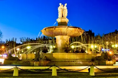 a fountain with a statue on top of it at night at Le Aix Rotonde Mirabeau - Centre Ville Terrasse Garage in Aix-en-Provence