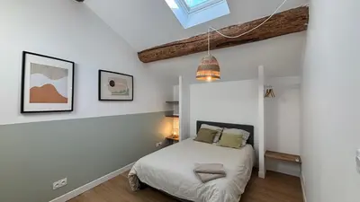 a bedroom with a bed and a skylight at Le Granier location in Robion en Luberon