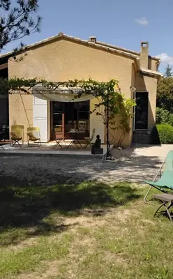 a house with a patio and chairs in front of it at fleur de gaïa chambres d'hôtes in Mazan