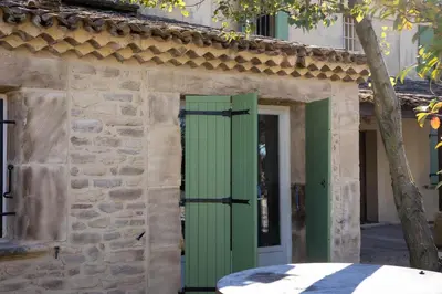 an entrance to a stone building with a green door at Domaine de la Myrtille in Pertuis
