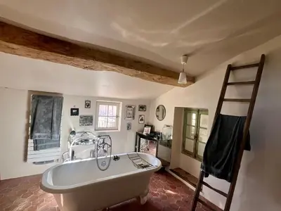 a bathroom with a large white bath tub and a ladder at Très beau mas à Bonnieux in Bonnieux