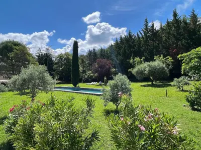 a garden with a swimming pool and trees at Très beau mas à Bonnieux in Bonnieux