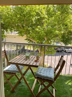 a wooden table and two chairs on a balcony at Studio cosy en Provence avec parking Le Monaco in Aix-en-Provence