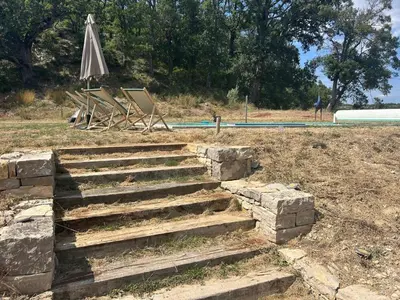 a set of stairs with an umbrella next to a pool at les Claveaux in Montfuron
