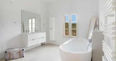 a white bathroom with a tub and a sink at les Claveaux in Montfuron