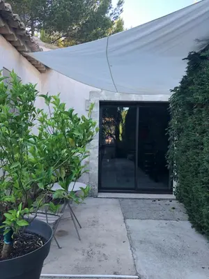 a white awning over a patio with a plant at Gîte Les Alpilles in Eygalières