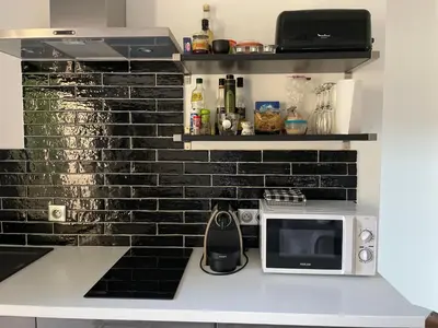 a kitchen with a white counter with a microwave at Gîte Les Alpilles in Eygalières
