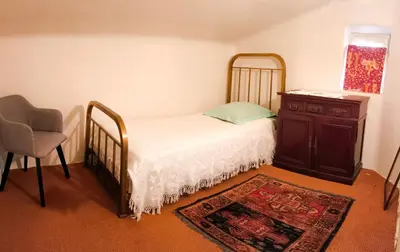 a bedroom with a bed and a dresser and a chair at Maison Robert in La Tour-dʼAigues