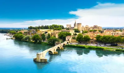 a bridge over a river with a city in the background at Mazet Arlequine in Eygalières