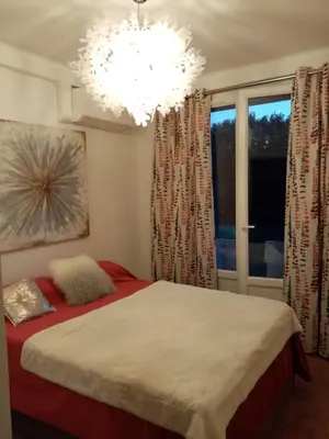 a bedroom with a bed and a chandelier at Aix centre charmant T2 climatisé parc jourdan in Aix-en-Provence