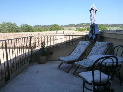 a patio with two chairs and a table on a balcony at Bastide Saint Maurin in Ansouis