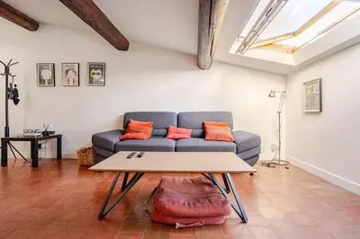 a living room with a couch and a table at Ecrin au cœur d'Aix-Vue sur la Place de la Mairie in Aix-en-Provence