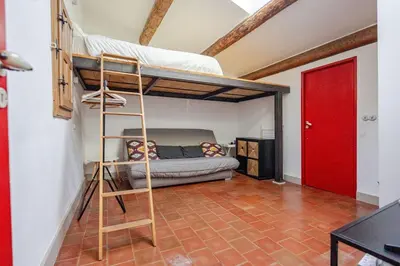 a room with a bunk bed and a ladder at Ecrin au cœur d'Aix-Vue sur la Place de la Mairie in Aix-en-Provence