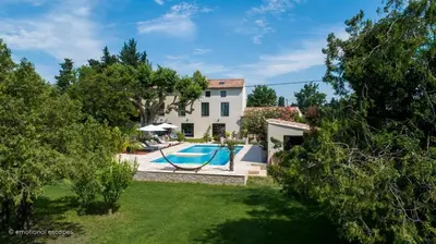 an exterior view of a house with a swimming pool at La Bastide Mas in Le Thor