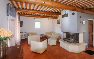 a living room with a fireplace and white furniture at Sarriette & Romarin in Apt