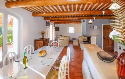a kitchen and living room with a table and chairs at Sarriette & Romarin in Apt