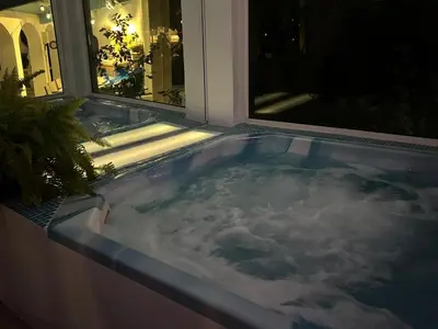 a hot tub in front of a window at night at villa spacieuse piscine jacuzzi 8 chambres 16 couchages in Saint-Chamas