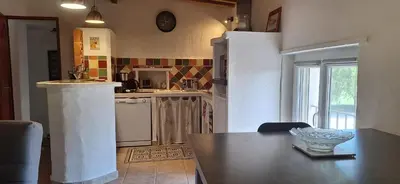 a kitchen with a table and a counter top at Complexe dans un grand Mas Provençal en campagne avec piscine privée in Monteux
