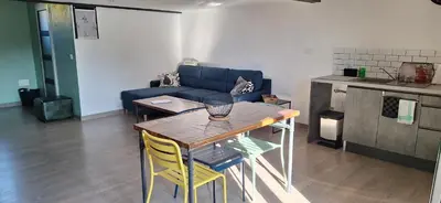 a living room with a table and a blue couch at Complexe dans un grand Mas Provençal en campagne avec piscine privée in Monteux