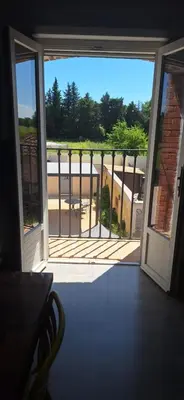 an open door to a balcony with a view at Complexe dans un grand Mas Provençal en campagne avec piscine privée in Monteux
