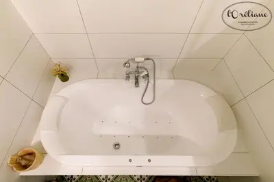 a white bath tub in a bathroom with tiles at CHAMBRES D'HÔTES L'Oréliane en Provence Adults Only in Châteauneuf-de-Gadagne