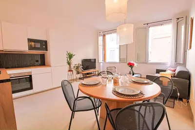 a kitchen and a living room with a table and chairs at Charme et Modernité au coeur d'Aix & Cours Mirabeau in Aix-en-Provence