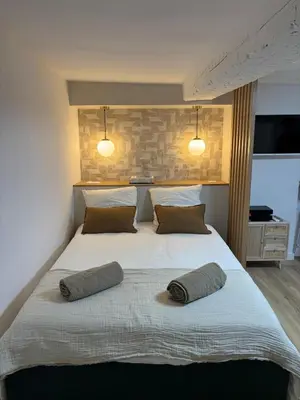 a bedroom with a large bed with two pillows on it at Magnifique studio centre d'Aix & Cours Mirabeau in Aix-en-Provence